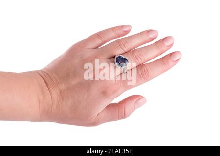 Zaffiro blu a forma di cuore anello prezioso su mano donna isolato su sfondo bianco. Primo piano dell'anello diamantato sulla mano femmina. Anello dorato bianco con Foto Stock