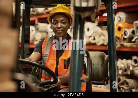 Donna africana operatore carrello elevatore che lavora in un magazzino Foto Stock