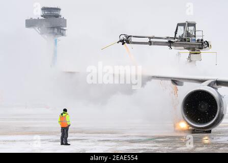 Schonefeld, Germania. 09 febbraio 2021: Un Airbus della compagnia aerea Eurowings viene sghiacciato all'aeroporto di Berlino-Brandeburgo Willy Brandt prima del decollo. Lo sbrinamento viene dapprima effettuato con una miscela acqua-glicole ad una temperatura di 60 gradi Celsius. Quindi, in una seconda fase, la pelle esterna del velivolo viene sigillata con glicole, impedendogli di ghiacciare di nuovo fino al decollo. Foto: Soeren Stache/dpa-Zentralbild/dpa Credit: dpa Picture Alliance/Alamy Live News Credit: dpa Picture Alliance/Alamy Live News Foto Stock