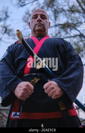 uomo che pratica la disciplina di sipalkido all'aperto in un lago in un giornata di sole con uniforme tradizionale Foto Stock