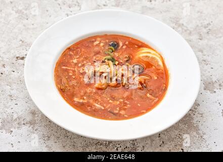 porzione di zuppa di pomodoro con salsiccia e olive in bianco piastra Foto Stock