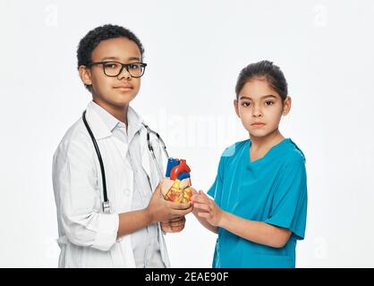 Due bambini carini che indossano un uniforme medica sono in posa e. guardando la fotocamera Foto Stock