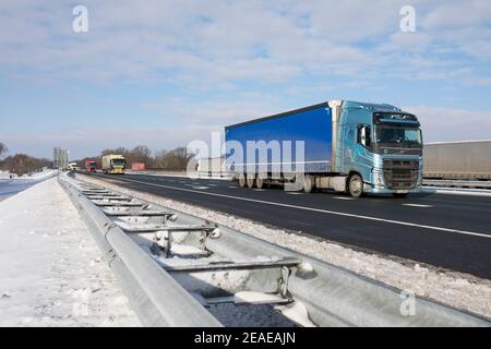 Camion polacco che passa sull'autostrada A67 durante l'inverno con neve Nei Paesi Bassi Foto Stock