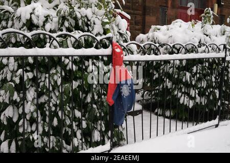 Glasgow, Regno Unito, il 9 febbraio 2021. Spiderman getta la giacca nella neve. Photo credit: Jeremy Sutton-Hibbert/ Alamy Live News. Foto Stock