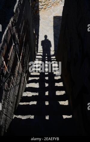 Immagine misteriosa di Long Shadow of Man su scale, scale o scale in Dark, Dingy Alley o vicolo Foto Stock