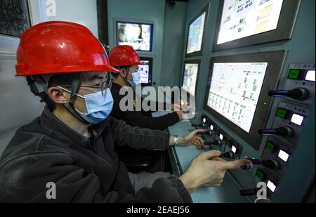 (210209) -- ZHONGNING, 9 febbraio 2021 (Xinhua) -- i lavoratori gestiscono la macchina di tunneling dello scudo all'interno di un tunnel che attraversa il Fiume giallo nella Contea di Zhongwei, città di Ningxia Hui Autonomous Reigon, 9 febbraio 2021. Oltre 100 lavoratori sono ancora in servizio nel tunnel per garantire lo sviluppo del progetto in tempo nonostante il prossimo Spring Festival, o il cinese Lunar New Year. Questo tunnel, il secondo ad attraversare il Fiume giallo in Ningxia, fa parte di un progetto più grande per fornire il servizio di riscaldamento ai residenti in Zhongning. (Xinhua/Feng Kaihua) Foto Stock
