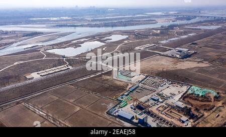 (210209) -- ZHONGNING, 9 febbraio 2021 (Xinhua) -- Foto aerea scattata il 9 febbraio 2021 mostra una vista generale del sito di costruzione della rete di condutture di riscaldamento della spina dorsale da parte del Fiume giallo nella Contea di Zhongwei, città di Zhongwei del Reigon Autonoma di Hui della Cina nord-occidentale. Oltre 100 lavoratori sono ancora in servizio nel tunnel per garantire lo sviluppo del progetto in tempo nonostante il prossimo Spring Festival, o il cinese Lunar New Year. Questo tunnel, il secondo ad attraversare il Fiume giallo in Ningxia, fa parte di un progetto più grande per fornire il servizio di riscaldamento ai residenti in Zhongning. (Xinhua/F Foto Stock