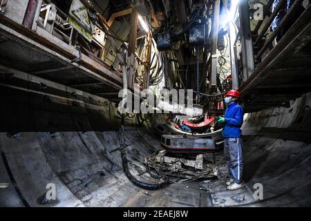 (210209) -- ZHONGNING, 9 febbraio 2021 (Xinhua) -- UN lavoratore assembla le linee di pipline all'interno di un tunnel attraverso il fiume giallo nella contea di Zhongwei, città del nord-ovest Ningxia Hui Autonomous Reigon della Cina, 9 febbraio 2021. Oltre 100 lavoratori sono ancora in servizio nel tunnel per garantire lo sviluppo del progetto in tempo nonostante il prossimo Spring Festival, o il cinese Lunar New Year. Questo tunnel, il secondo ad attraversare il Fiume giallo in Ningxia, fa parte di un progetto più grande per fornire il servizio di riscaldamento ai residenti in Zhongning. (Xinhua/Feng Kaihua) Foto Stock