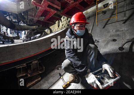 (210209) -- ZHONGNING, 9 febbraio 2021 (Xinhua) -- UN lavoratore assembla le linee di pipline all'interno di un tunnel attraverso il fiume giallo nella contea di Zhongwei, città del nord-ovest Ningxia Hui Autonomous Reigon della Cina, 9 febbraio 2021. Oltre 100 lavoratori sono ancora in servizio nel tunnel per garantire lo sviluppo del progetto in tempo nonostante il prossimo Spring Festival, o il cinese Lunar New Year. Questo tunnel, il secondo ad attraversare il Fiume giallo in Ningxia, fa parte di un progetto più grande per fornire il servizio di riscaldamento ai residenti in Zhongning. (Xinhua/Feng Kaihua) Foto Stock