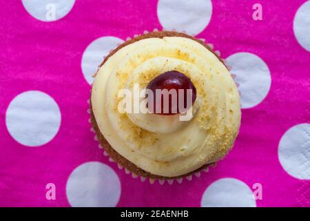 Biscake, biscotto incontra cupcake, Cherry Cake-well da M&S impostato su rosa polka puntini tovagliolo serviette Foto Stock