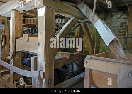 Meccanismo di lavoro del Lurgashall Mill, che mostra la farina che scorre nel contenitore. Weald e Downland Open Air Museum, Singleton, vicino a Chichester, West Susse Foto Stock