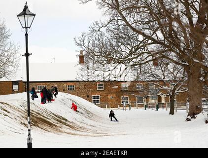 Oakham, Rutland, Regno Unito. 9 febbraio 2021. Meteo nel Regno Unito. I più giovani slittano lungo un pendio in Cutts Close Park, mentre la temperatura nel Regno Unito è crollata al suo più basso in un decennio. Credit Darren Staples/Alamy Live News. Foto Stock