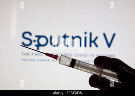 OXFORD, UK - Febbraio 2020: Logo del vaccino della covid Sputnik V con siringa per iniezione Foto Stock