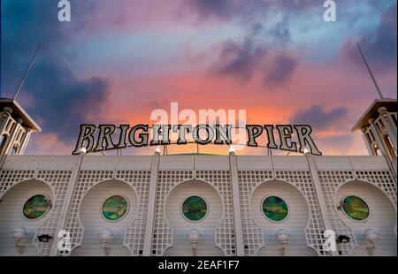 Cartello del molo di Brighton sopra l'ingresso al Brighton Pier Palace in serata al Tramonto, Sussex, Inghilterra, Regno Unito Foto Stock