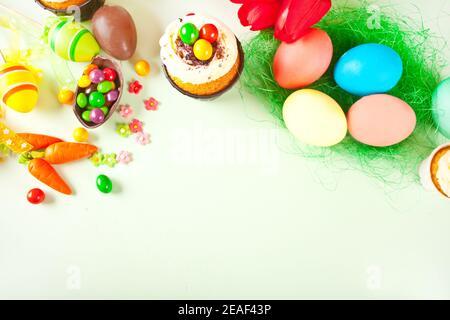 Set di Pasqua con uova colorate, carote, caramelle, cupcake. Vista dall'alto spazio di copia Foto Stock