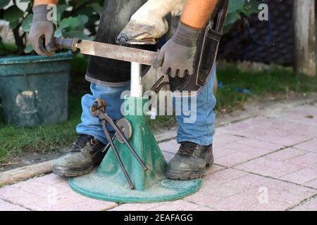 Fabbro ferriero che grattava lo zoccolo del cavallo Foto Stock