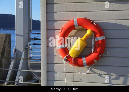 Lifebuoy (o cintura di salvataggio) accanto a un fiordo in Norvegia. Attrezzature di sicurezza per l'acqua. Foto Stock