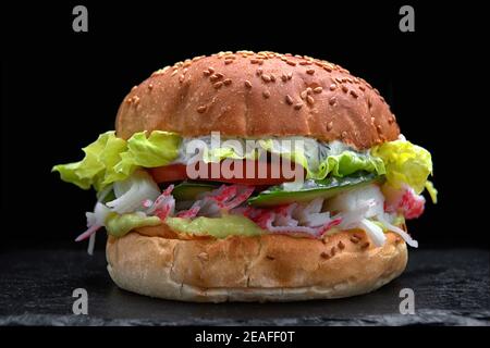 Hamburger, hamburger con bastoncini di granchio, carne di granchio, cetriolo, pomodoro, lattuga, salsa, su fondo nero Foto Stock