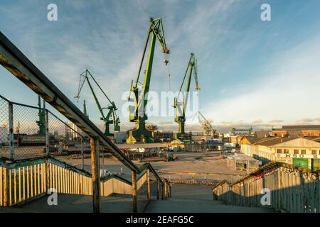 Gdansk, Polonia - 05.06.2017: Autogru per il carico di navi vecchio porto di Danzica sul Mar Baltico. Bella scena industriale in luce dorata. Foto Stock