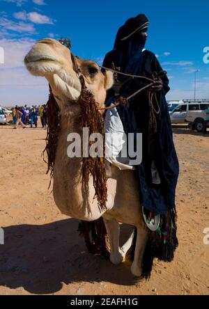 Tuareg uomo che cavalca il suo cammello, Tripolitania, Ghadames, Libia Foto Stock