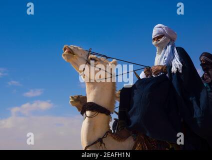 Tuareg uomo che cavalca il suo cammello, Tripolitania, Ghadames, Libia Foto Stock