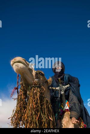 Tuareg uomo che cavalca il suo cammello, Tripolitania, Ghadames, Libia Foto Stock