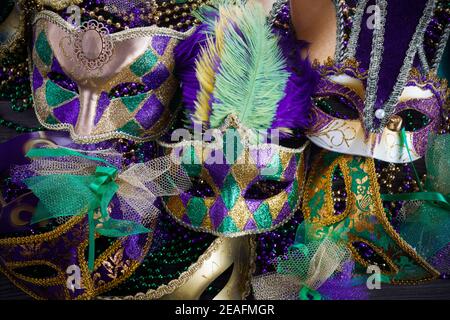 Un gruppo di maschere Veneziane e del nuovo Orlean Mardi gras con perle colorate su sfondo scuro Foto Stock