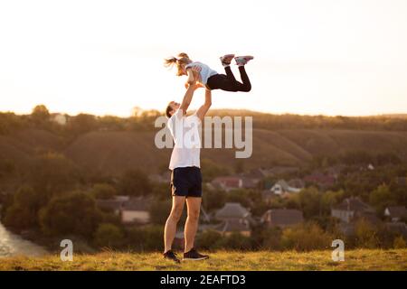 Padre e figlia si divertono insieme. Papà getta sua figlia in cielo Foto Stock