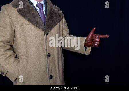 Ritratto di uomo in camice e vestito con Finger Gun Gesture su sfondo nero. Film Noir Agente Segreto Spy Hero. Detective combattere il crimine. Foto Stock