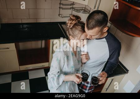 San Valentino a casa. Rapporto romantico qualità tempo. Coppia giorno lento trascorso all'interno, bere caffè e abbracciare in cucina Foto Stock