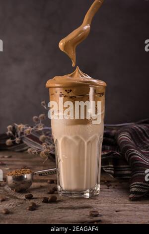 Caffè Dalgona. Bevanda ghiacciata montata con caffè istantaneo popolare in Corea cocktail cremoso in bicchieri alti. Fotografia di cibo con moody scuro Foto Stock