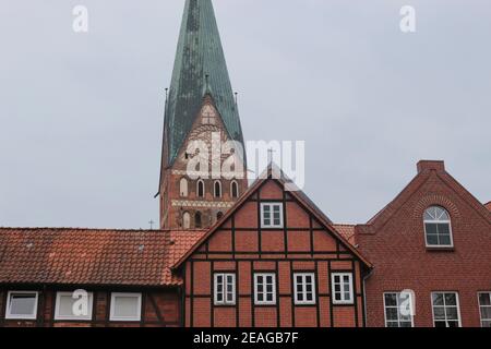 La chiesa di San Nicolai, costruita nel XV secolo in stile gotico in mattoni, e le storiche case in mattoni. Città vecchia di Lüneburg, Germania. Foto Stock