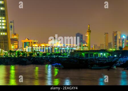 La Grande moschea del Kuwait dietro un porto dhow vicino al souq Sharq in Kuwait druing notte. Foto Stock