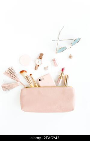 Composizione piatta con sacchetto cosmetico rosa con prodotti cosmetici, isolato su fondo bianco. Disposizione piatta, vista dall'alto. Foto Stock