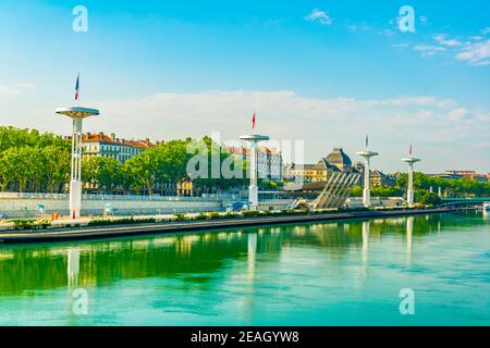 Pennoni giganti oltre ad una piscina pubblica sulla riva del fiume Rodano a Lione, Francia Foto Stock