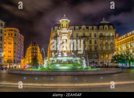 Vista notturna di una bella fontana in marmo su Place des Jacobins a Lione, Francia Foto Stock