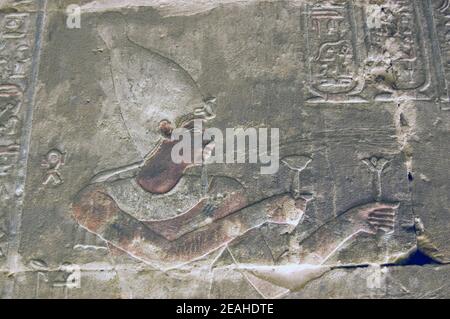 Antica scultura egiziana del Faraone che offre un loto e un fiore papiro agli dei. Interno del Tempio di Horus, Edfu, Egitto. Foto Stock