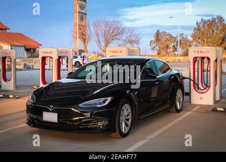 Firebaugh, USA - 21 gennaio 2021: Auto elettrica nera di lusso Tesla Model S 75D ad un Supercharger da 250 kW sulla California Highway 5 Foto Stock