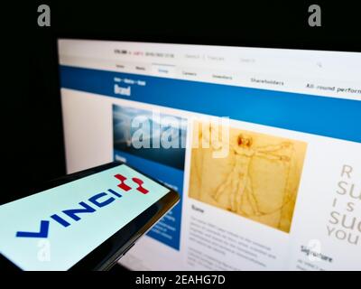 Telefono cellulare con logo di concessioni francesi e società di costruzioni Vinci S.A. su schermo di fronte al sito web. Focus sul centro del display del cellulare. Foto Stock