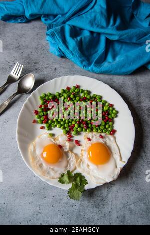 Uovo poach lato soleggiato su un ingrediente alimentare sano su un piatto con verdure bollite Foto Stock