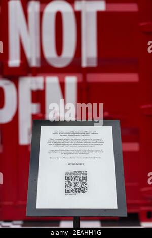 Vista verticale. Presentazione con cartello di Louis Vuitton rosso che colpisce i contenitori di spedizione sul retro. Singapore. Foto Stock