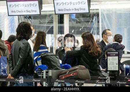 Tokyo, Giappone. 07 febbraio 2021. I viaggiatori che indossano facemaskes come misura preventiva contro la diffusione della coda di covid-19 in un punto di check-in all'aeroporto di Narita. Poiché l'aumento delle infezioni da coronavirus Covid-19, le autorità giapponesi hanno chiuso i confini per la maggior parte dei viaggiatori. Credit: SOPA Images Limited/Alamy Live News Foto Stock