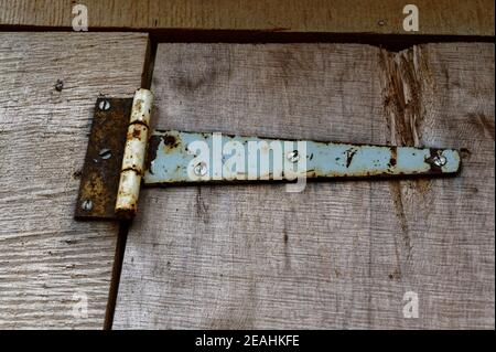 Una vecchia cerniera su una porta rustica in legno Foto Stock