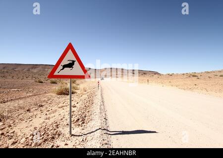 Un cartello di attenzione antilope su una strada desertica polverosa Foto Stock