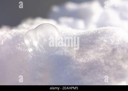 le bolle di sapone congelate giacciono nella neve. Foto di alta qualità Foto Stock