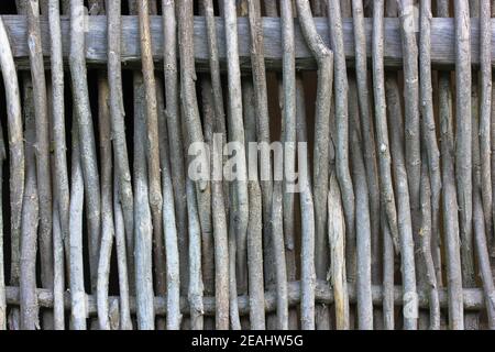 Una recinzione rustica in vimini in primo piano. Recinzione fatta di verghe marroni di legno in un villaggio ucraino. Sfondi e texture in legno. Foto di alta qualità Foto Stock
