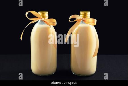 Eggnog fatto in casa in bottiglie su sfondo scuro Foto Stock