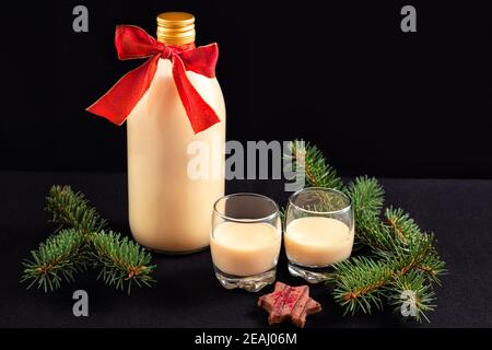 Eggnog fatto in casa in bottiglia e due bicchieri con biscotti di Natale Foto Stock