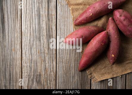 Patate dolci su un vecchio sfondo di legno Foto Stock