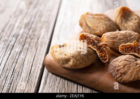 Fichi secchi su un vecchio sfondo di legno Foto Stock